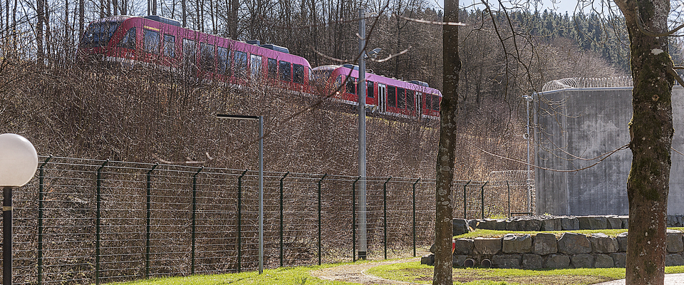 Ein Zug fährt an der Anstalt vorbei.